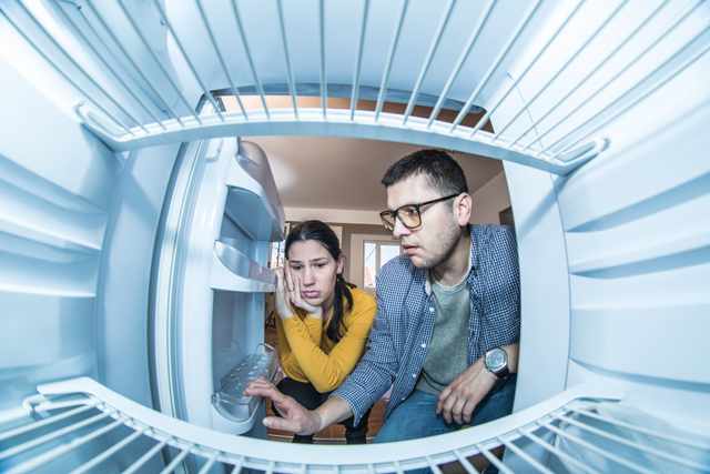 Couple inspecting inside a fridge Couple inspecting inside a fridge