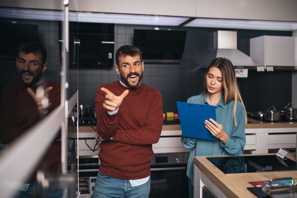 A man asking a woman about an appliance
