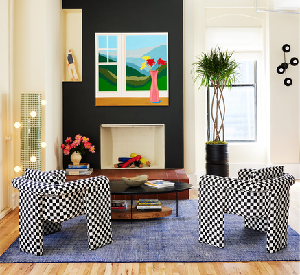 A small living room with a fireplace and checkerboard-patterned chairs