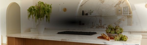 A white and light wood kitchen with a marble backsplash, designed by Nina Takesh 