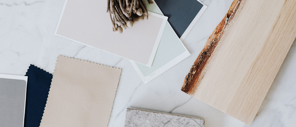 A series of swatches of soft colors, including beige, layered with wood, stone and other natural materials to form a pallet