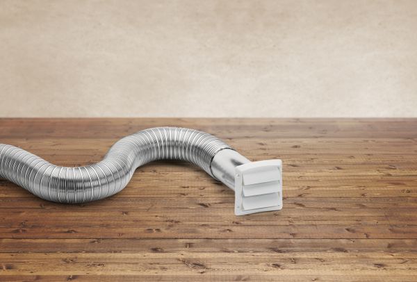A dryer hose on wooden flooring 
