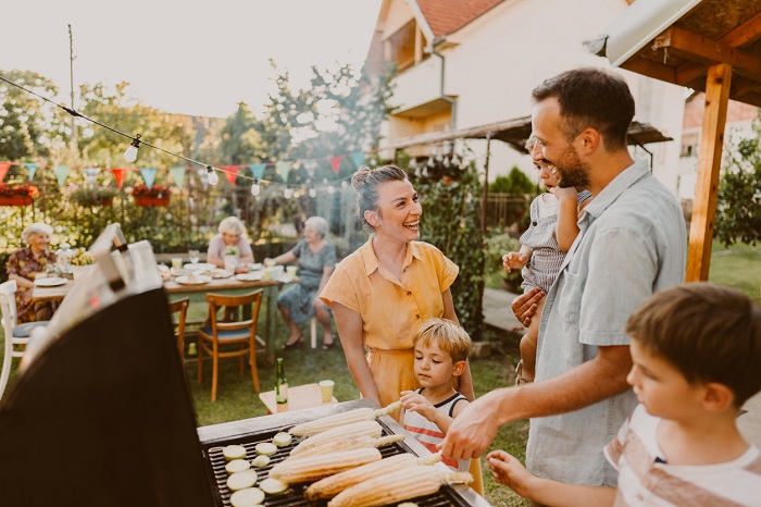 Young family having a barbecue party in their backyard.