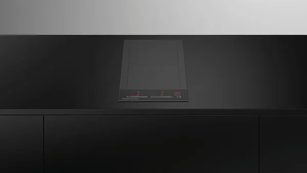 The Fisher & Paykel Series 9 CI122DTB4 cooktop installed into black countertops 