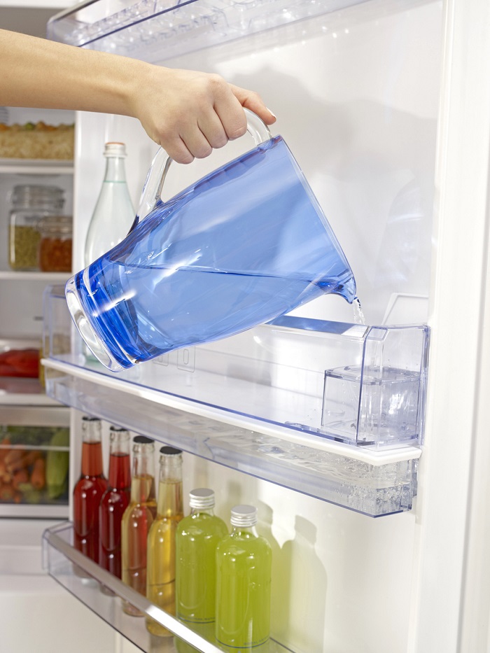 Filling the water tank inside of fridge.