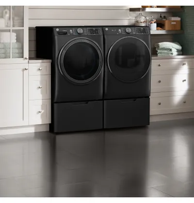 The GE GFD65GSPVDS dryer and washer in a laundry room