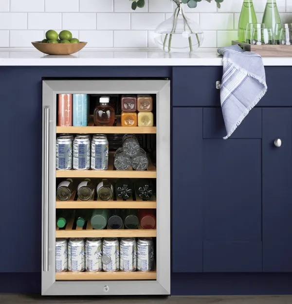 The GE GVS04BQNSS wine cooler installed within blue cabinets 