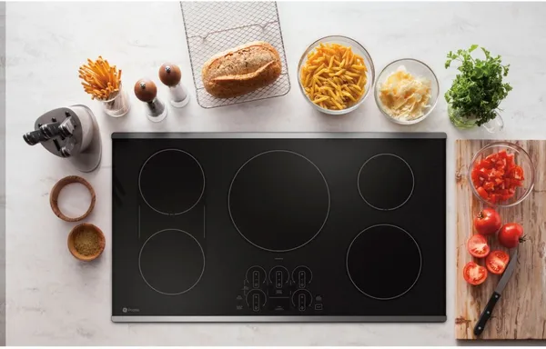 Overhead view of the GE Profile PHP9036STSS induction cooktop with various foods