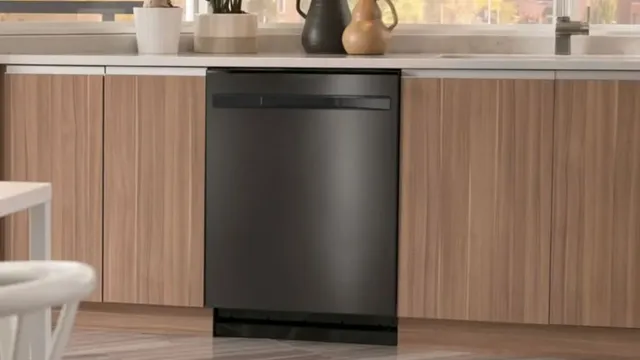 front view of a black stainless steel ge profile dishwasher built into a kitchen island with light wooden cabinetry