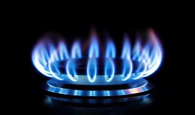 A close-up of a gas burner against a black background 