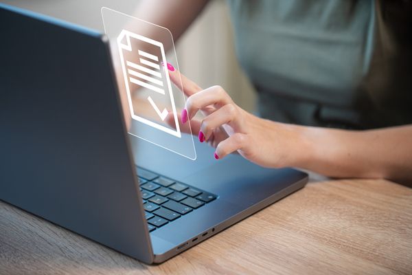 A graphic checkmark on an overlay of a person using a laptop 
