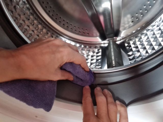 Credit: iStock Close view of a person cleaning the inside of a washer gasket
