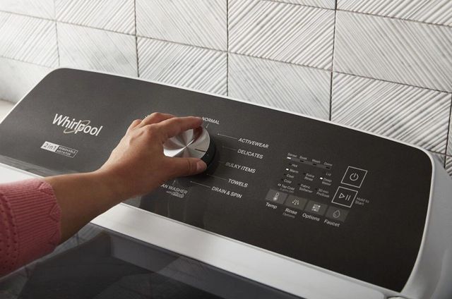 whirlpool-washer-features closeup view of a hand turning the settings knob on the whirlpool washer