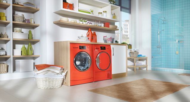 Front view of a modern laundry room with a red washer and dryer.