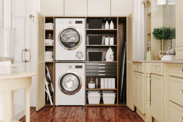 front view of stacked laundry appliances in a modern beige laundry room
