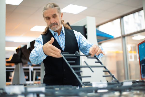 A middle-aged man reviewing a gas range in a store 