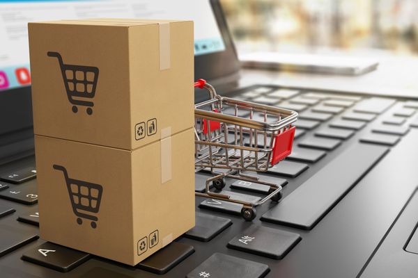 A 3D rendering of a mini shopping cart and boxes on a laptop 