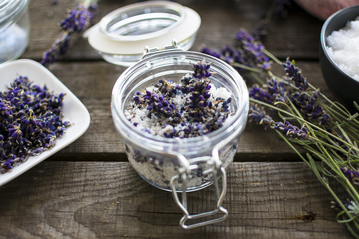 Jar filled with bath salts and lavender with lavender flowers on each side.