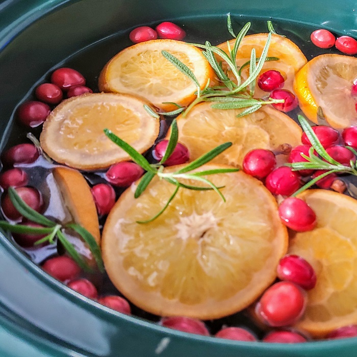 Pot of potpourri mixed with oranges, cranberries, and other garnish.