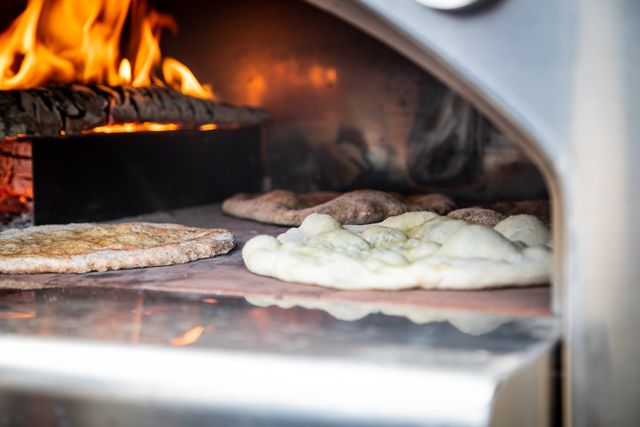 Close view of flatbreads cooking in a wood fired built in pizza oven