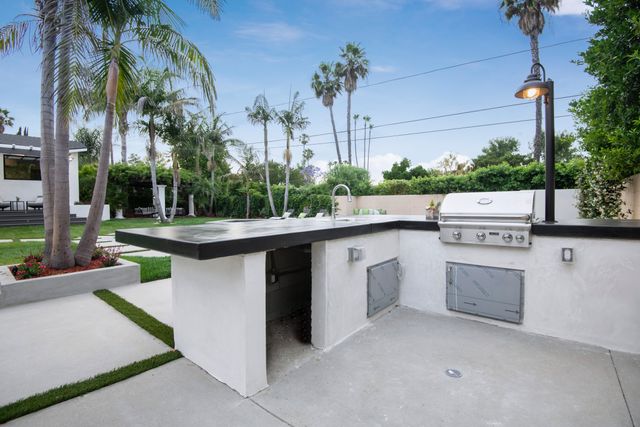 Front view of an outdoor kitchen with a grill and storage with space for an outdoor fridge and sink