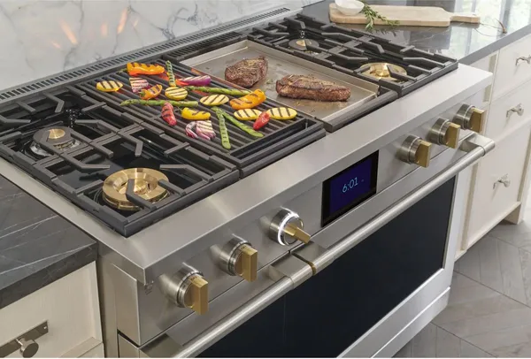An overhead view of the Overhead view of the Monogram ZDP484NGTSS cooking vegetables and steak 