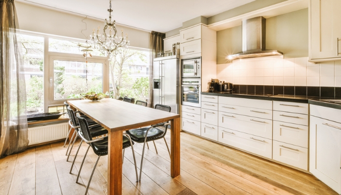 A modern, luxury kitchen is lit in the morning and well organized and clean.
