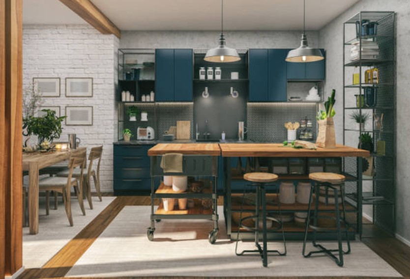 front view of a modern trendy kitchen with dark blue cabinets, a light wood island, gray counters and backsplash, and white brick walls
