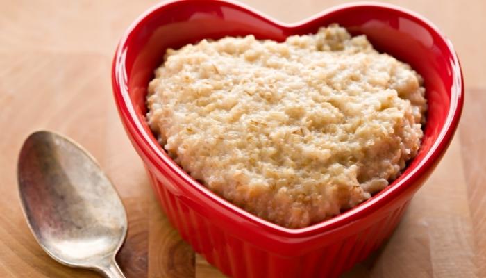 Oatmeal in heart-shaped bowl with spoon