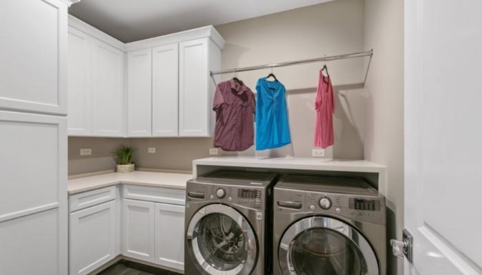  Laundry room with clothes hanging from a bar above machines