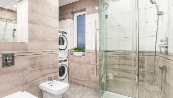 Bathroom with stacked laundry machines in it