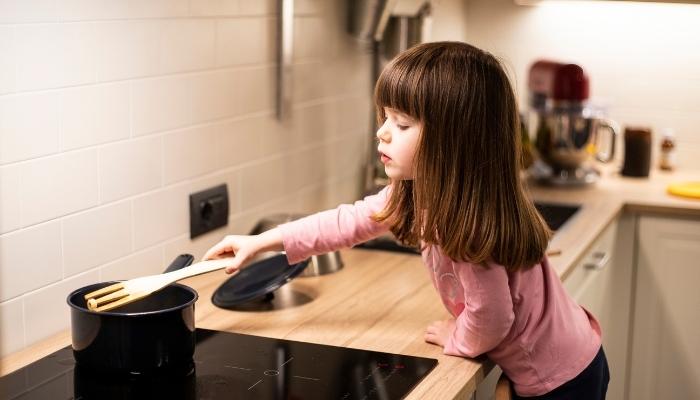 Kid stirring pot on induction cooktop