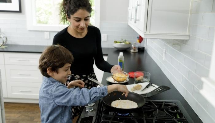 Mom and child cooking on gas cooktop