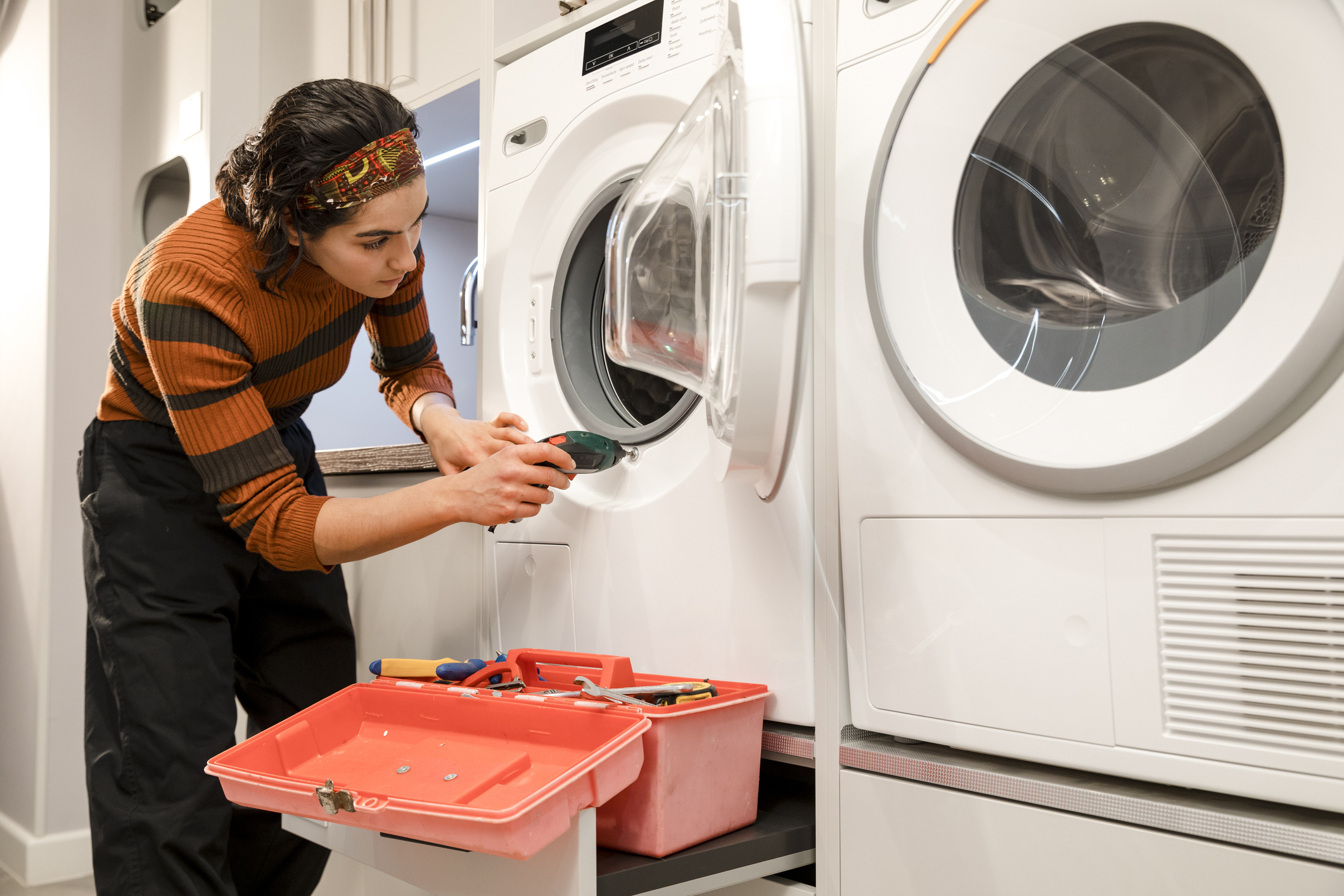 woman repairing washing machine
