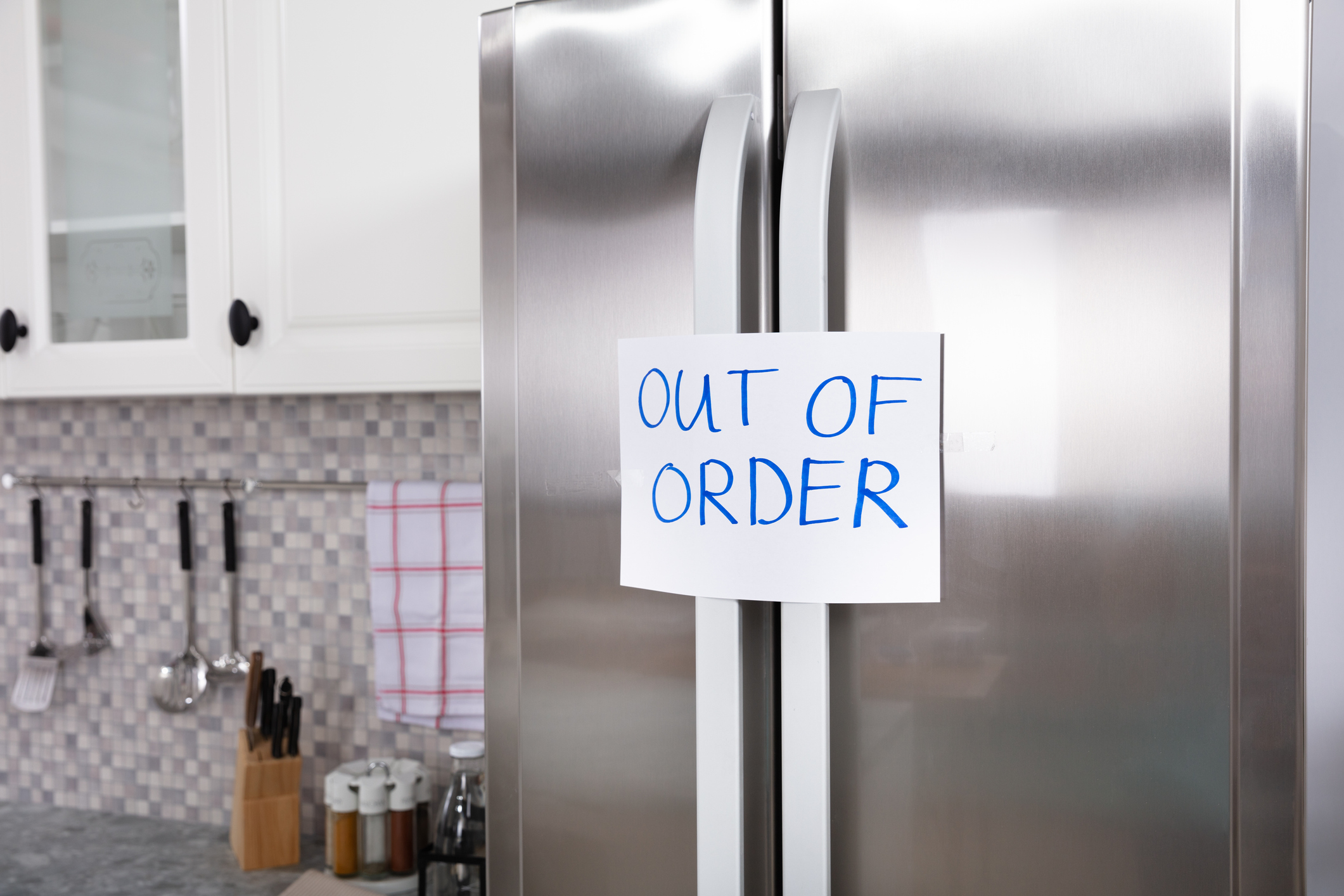 stainless steel fridge with out of order sign on it 