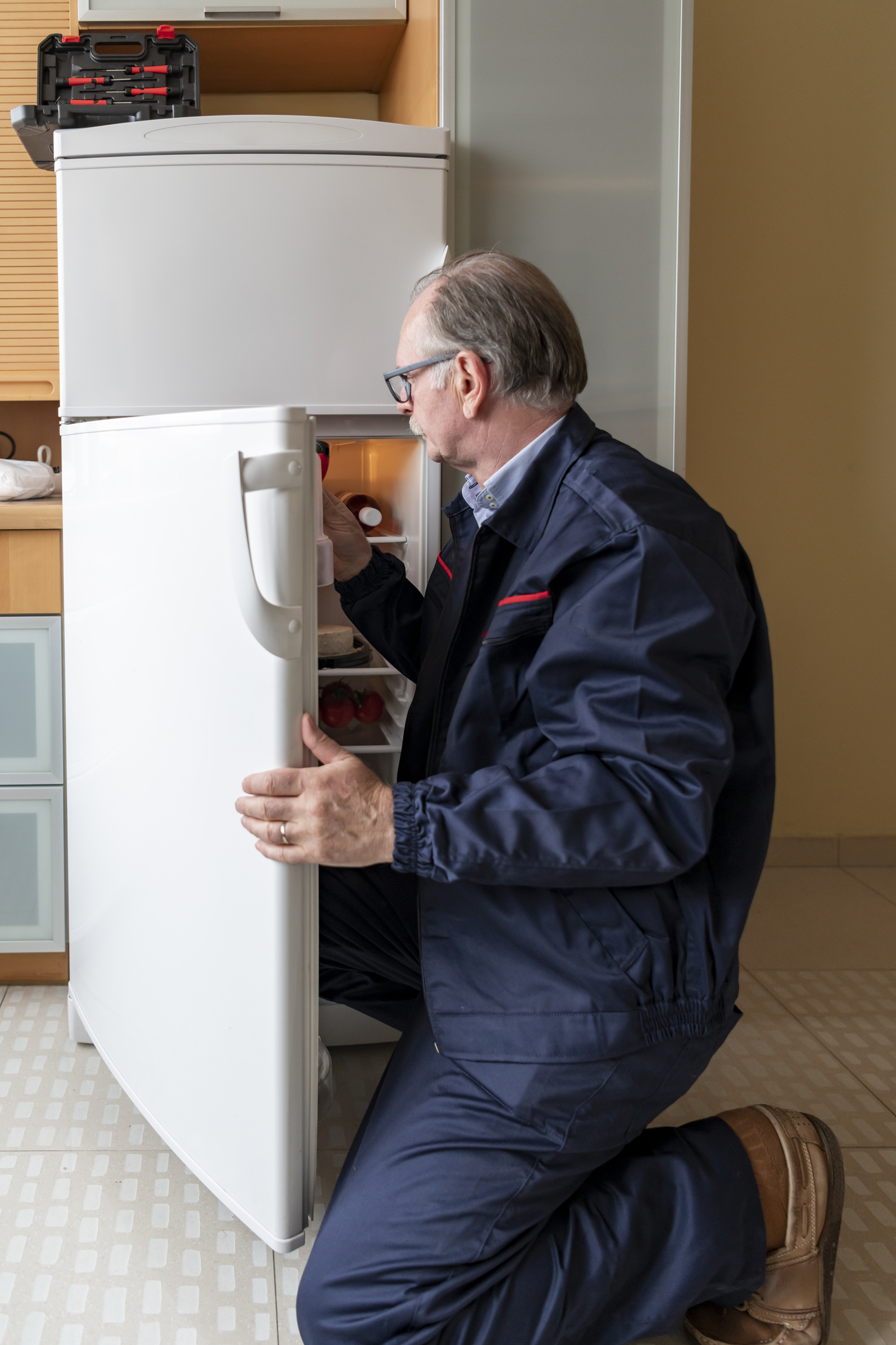 technician fixing refrigerator