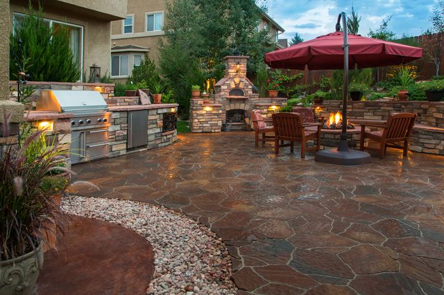 luxurious outdoor kitchen with seating area behind a home