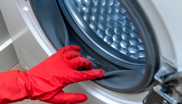 Close up of gloved hand cleaning washer
