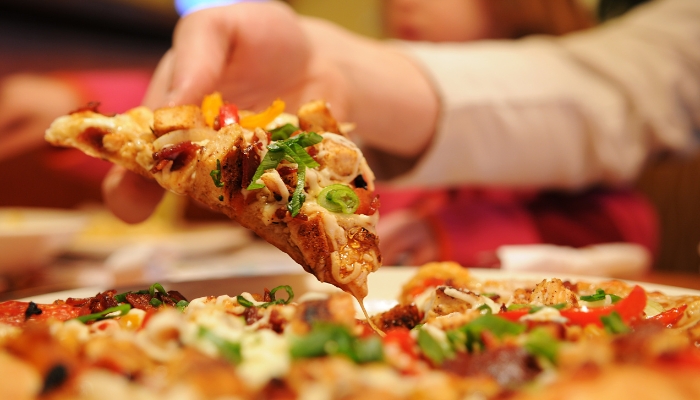 Hand picking up slice of pizza