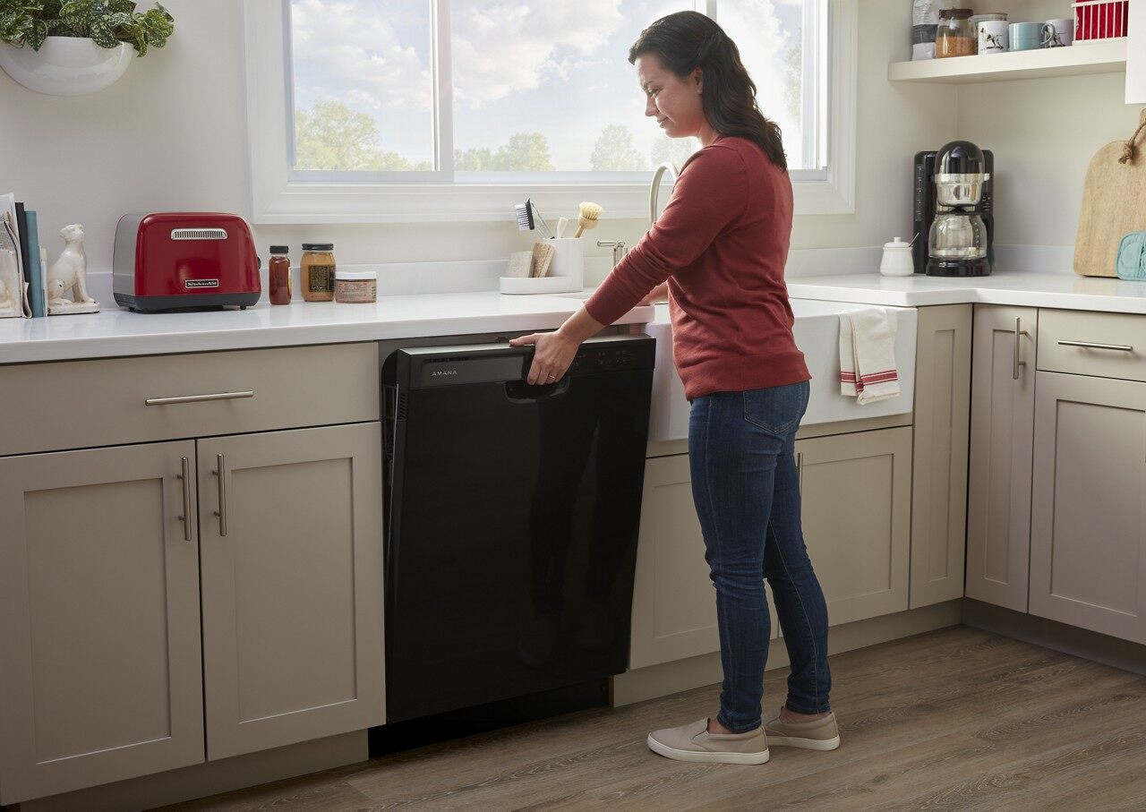 woman opening black dishwasher