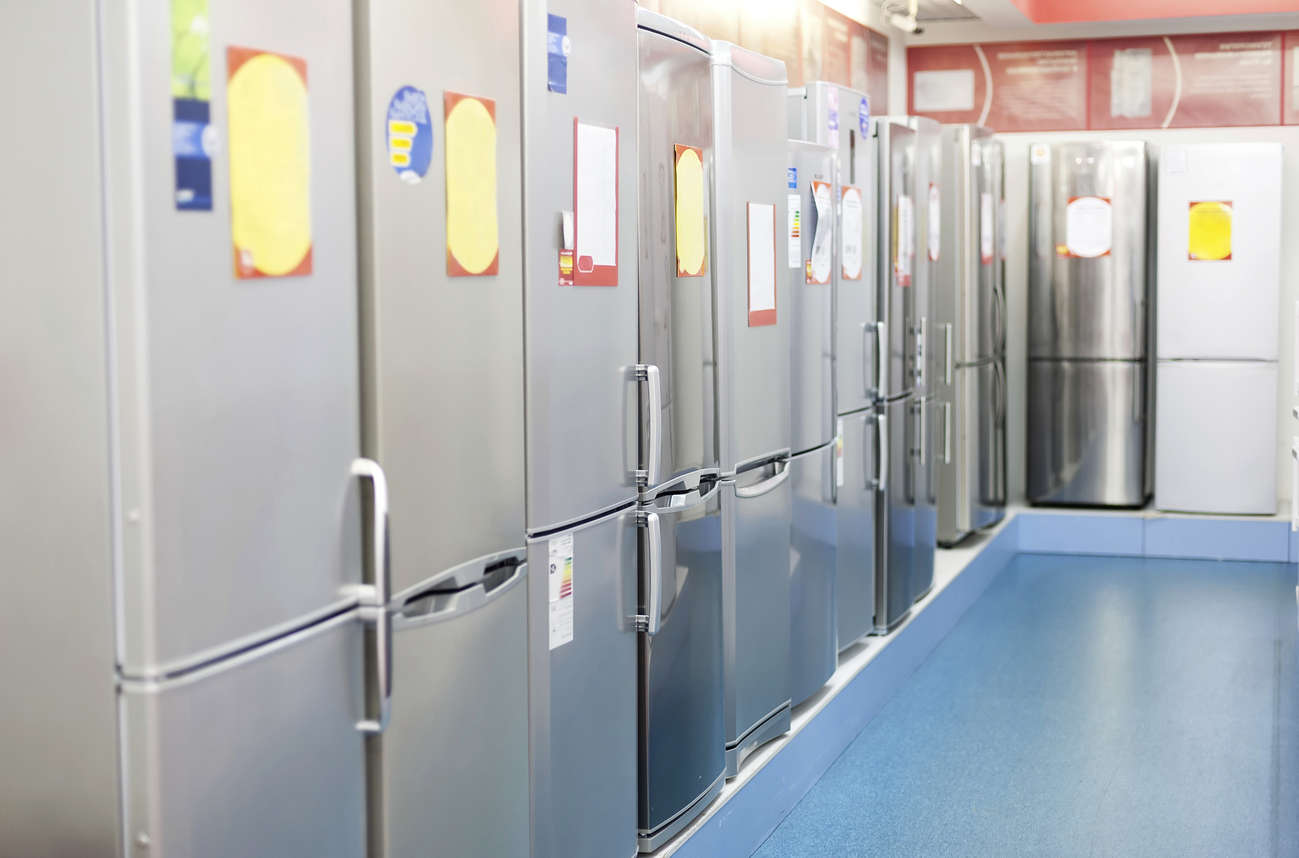 row of on sale refrigerators in showroom