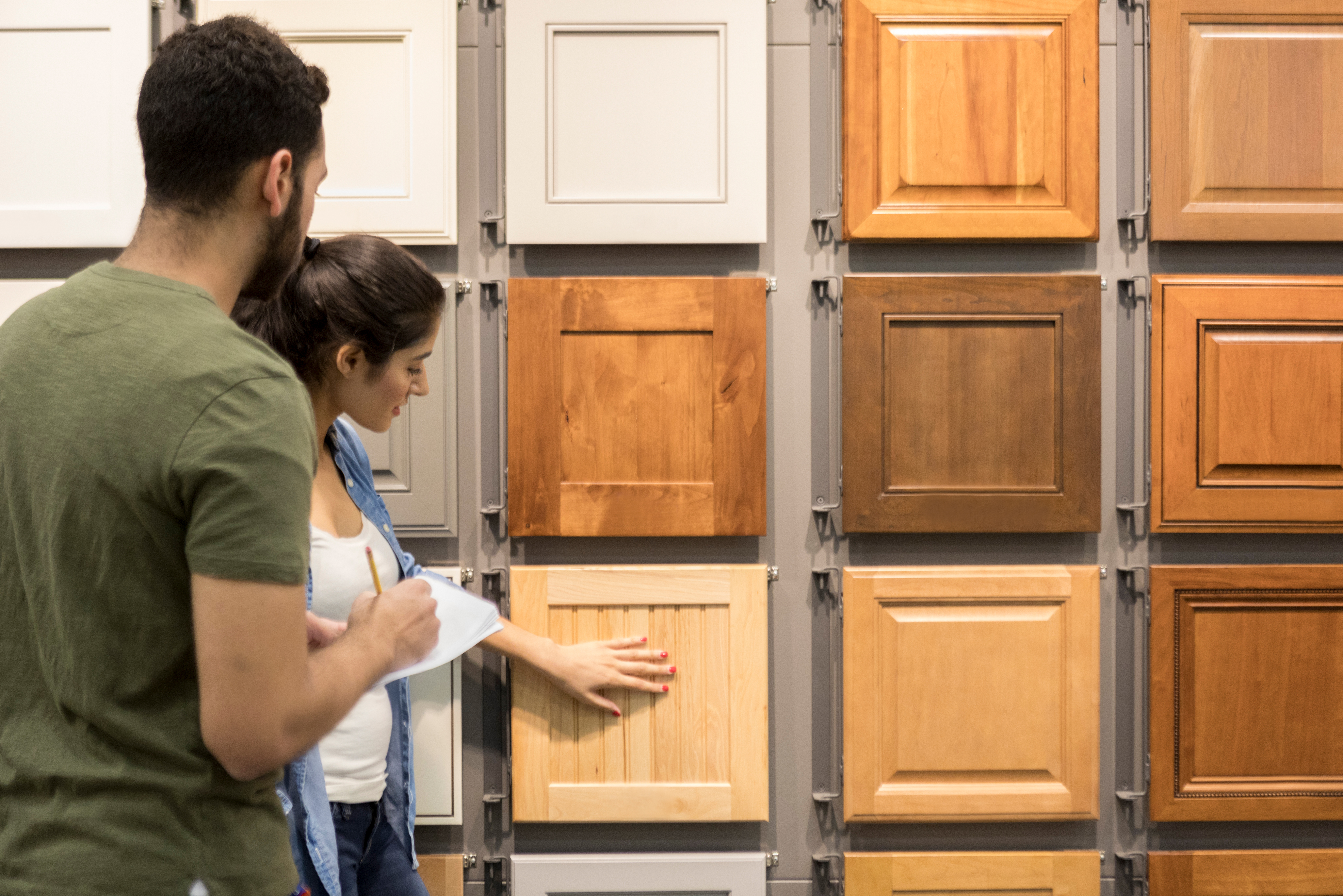 Two people examining various cabinet types