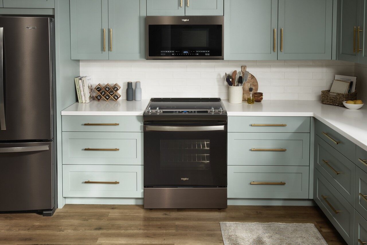 teal kitchen with black Whirlpool appliances