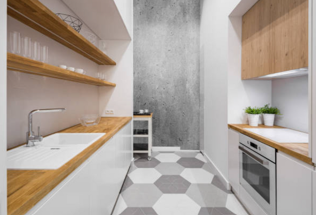 front view of a modern galley style kitchen with under cabinet lifhting