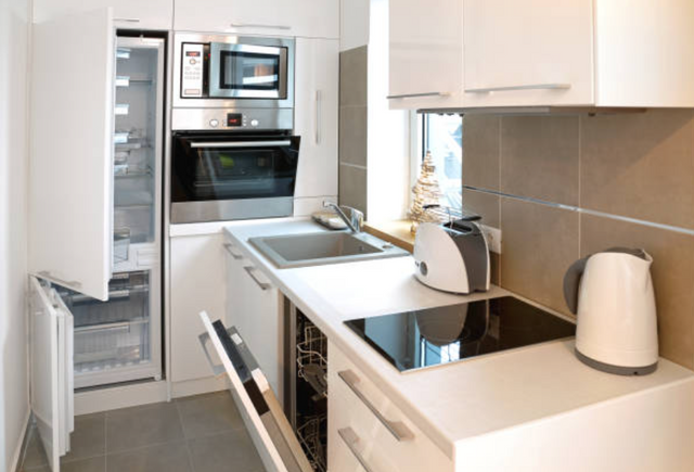 front view of a small white galley size apartment kitchen
