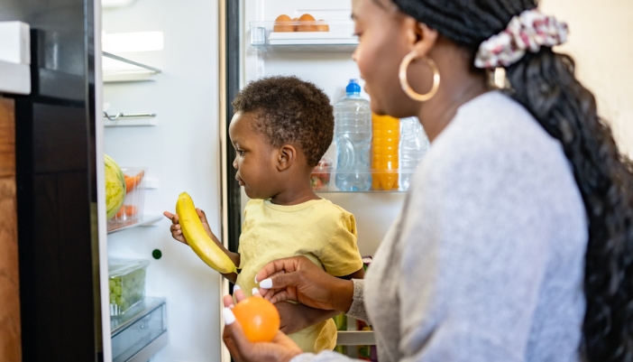 A little boy and his mom go through a fridge to look for food.