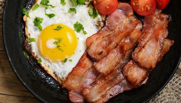 Eggs with bacon and tomatos in a skillet