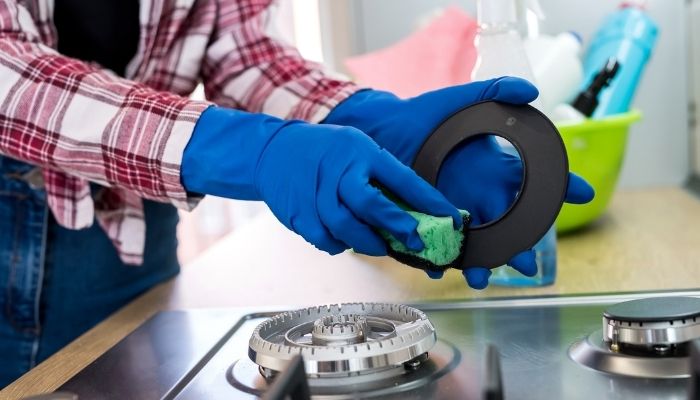 person cleaning burner caps