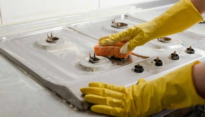 person cleaning stovetop
