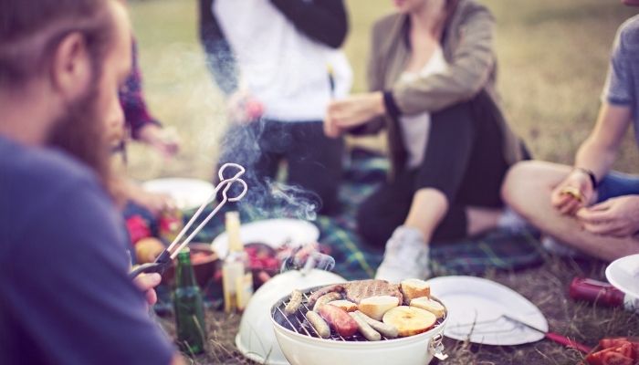 Group of people using portable grill outside